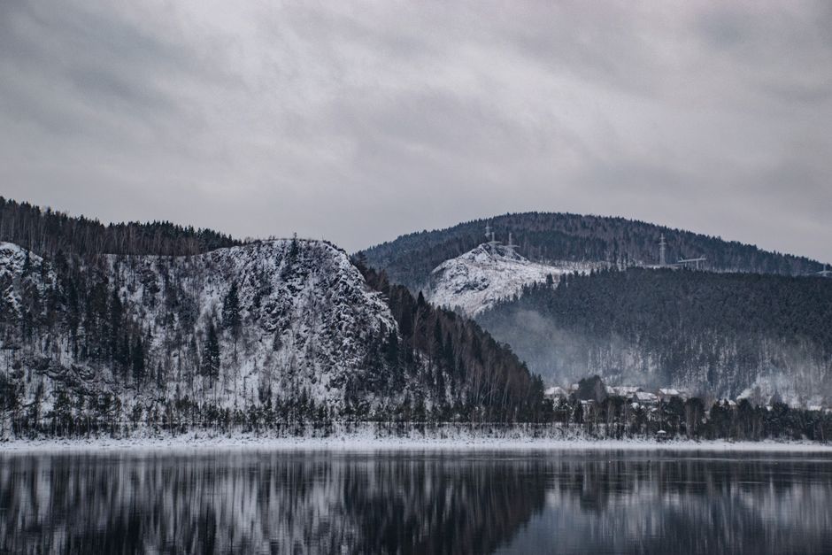 A serene winter landscape of mountains reflected in a calm lake, capturing the essence of nature's tranquility.
