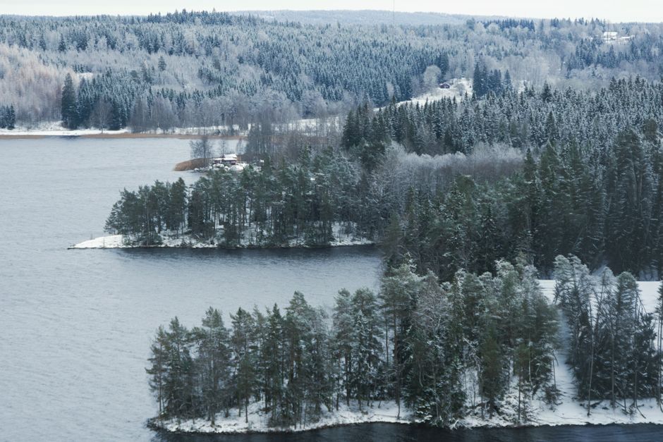 A serene aerial view of snow-covered forests and lakes in Tenhult, Jonkoping County, Sweden during winter.